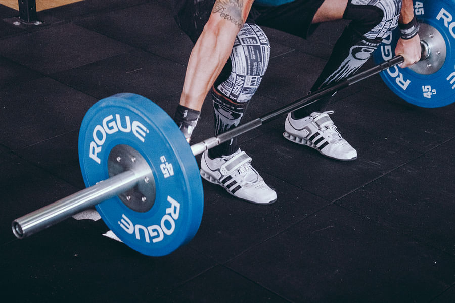 Weightlifter performing a heavy squat wearing weightlifting shoes